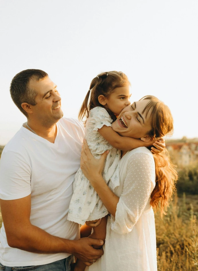 A man holding a little girl in a field